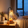 Flower candle warmer lamp glowing on a bedside table
